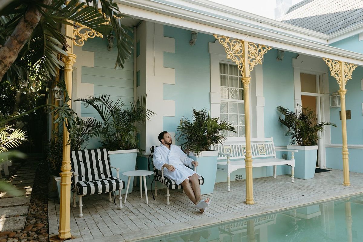 A guest relaxing on the verandah at Amina beside the pool