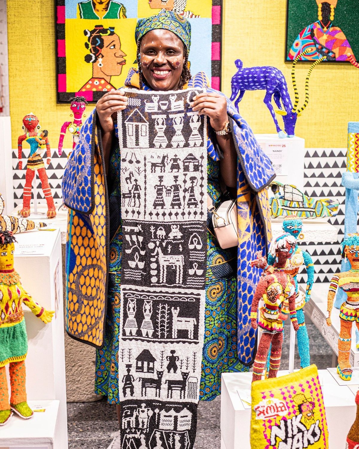 A beaded artwork held up at the Monkeybiz studio