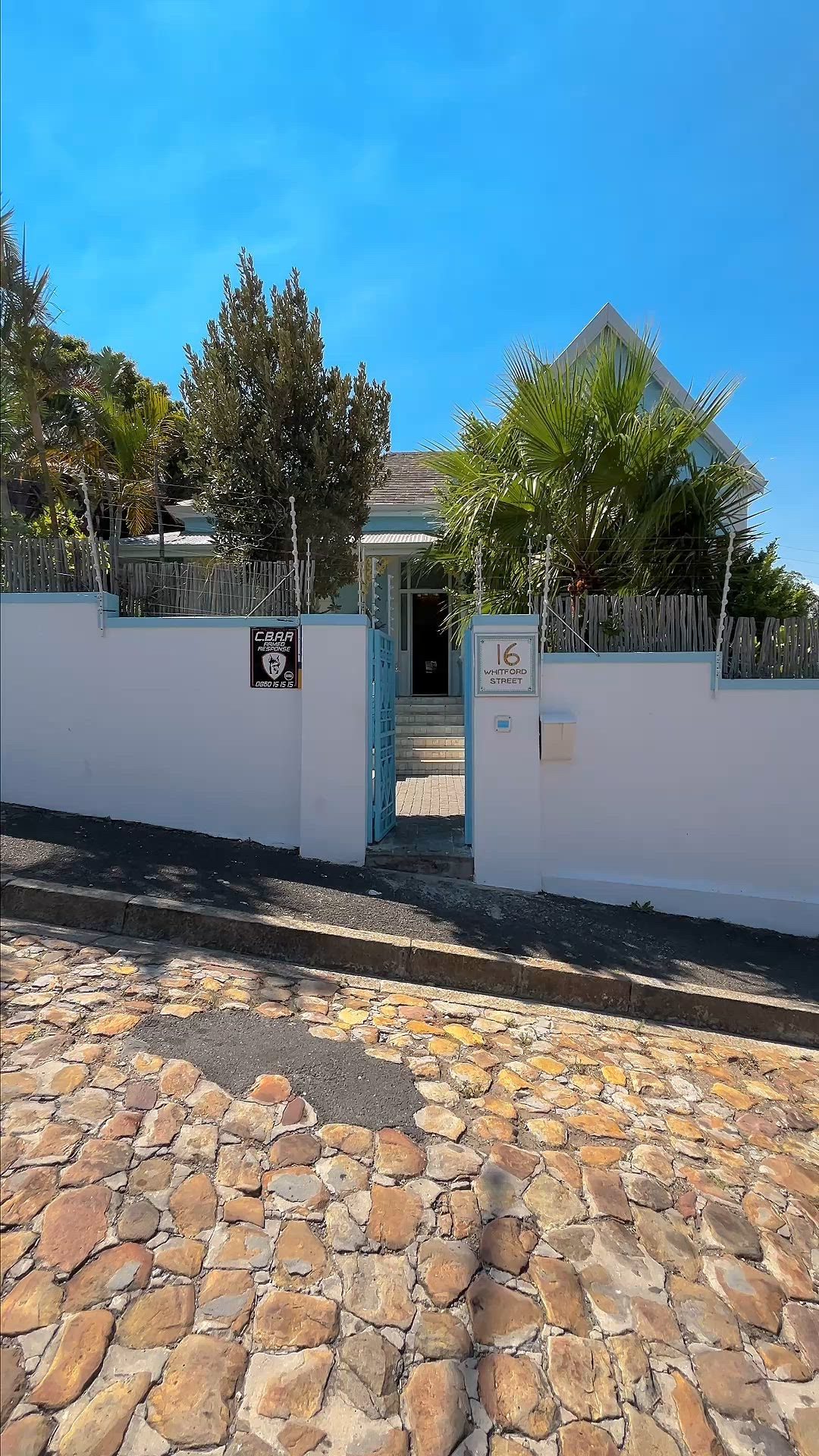 The blue gate of Amina standing open onto the cobbles of Whitford Street