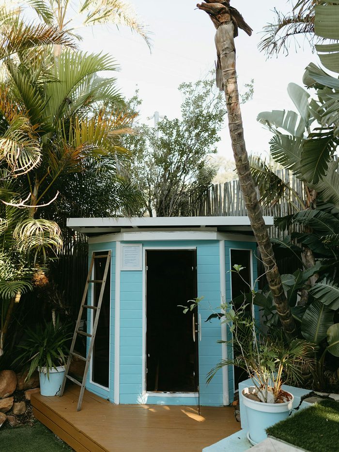 The infrared sauna cabin on its deck among the palms