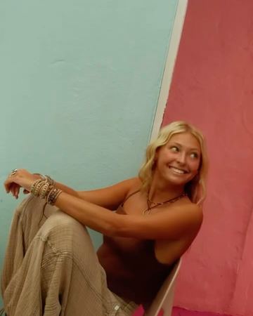 A smile on a chair against the mint and pink walls