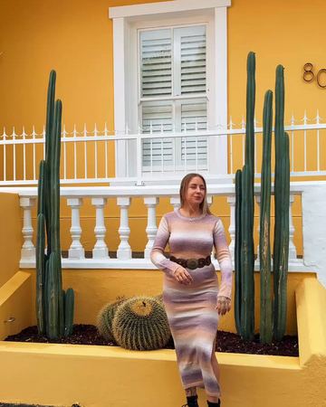 A guest outside a yellow house with cacti on a Bo-Kaap street