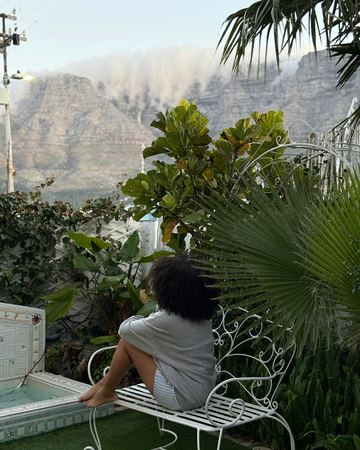 A guest on the white iron bench looking out at Table Mountain