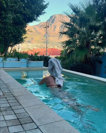 A guest swimming the length of the pool, the mountain ahead
