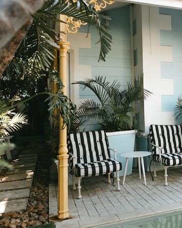 Striped chairs and palms in the corner of the verandah