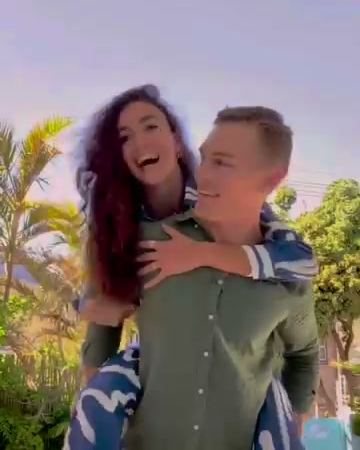 A couple laughing, a piggyback by the pool