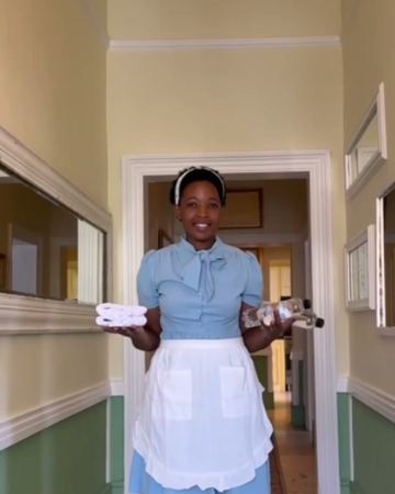 A smile and fresh towels in the hallway under the chandelier