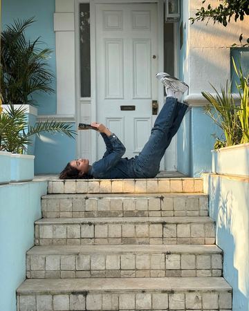 Lying on the front steps with her feet up on the door