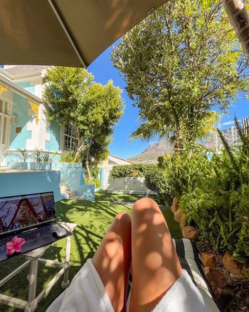 Working in the sun: a laptop beside a lounger in the garden