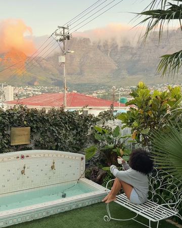 On the bench by the wishing well as a pink cloud lights Table Mountain