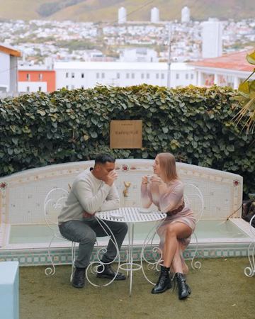 A couple over tea at the iron table by the wishing well, Table Mountain above the rooftops