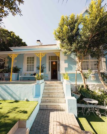 The garden front from the path, with a white iron table