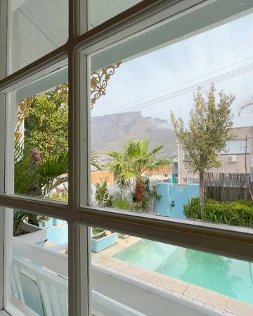 A room window looking out to the pool and Table Mountain