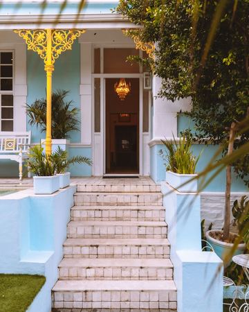 The front door at the top of the steps under the yellow lace, the chandelier inside