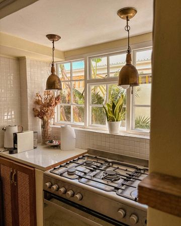 The Cottage Room kitchen, with pendant lamps and a gas stove