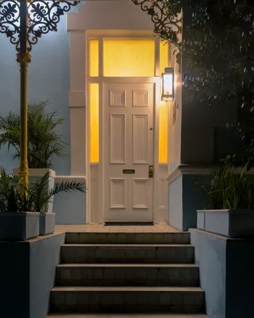 The front door glowing yellow at night, the lantern lit
