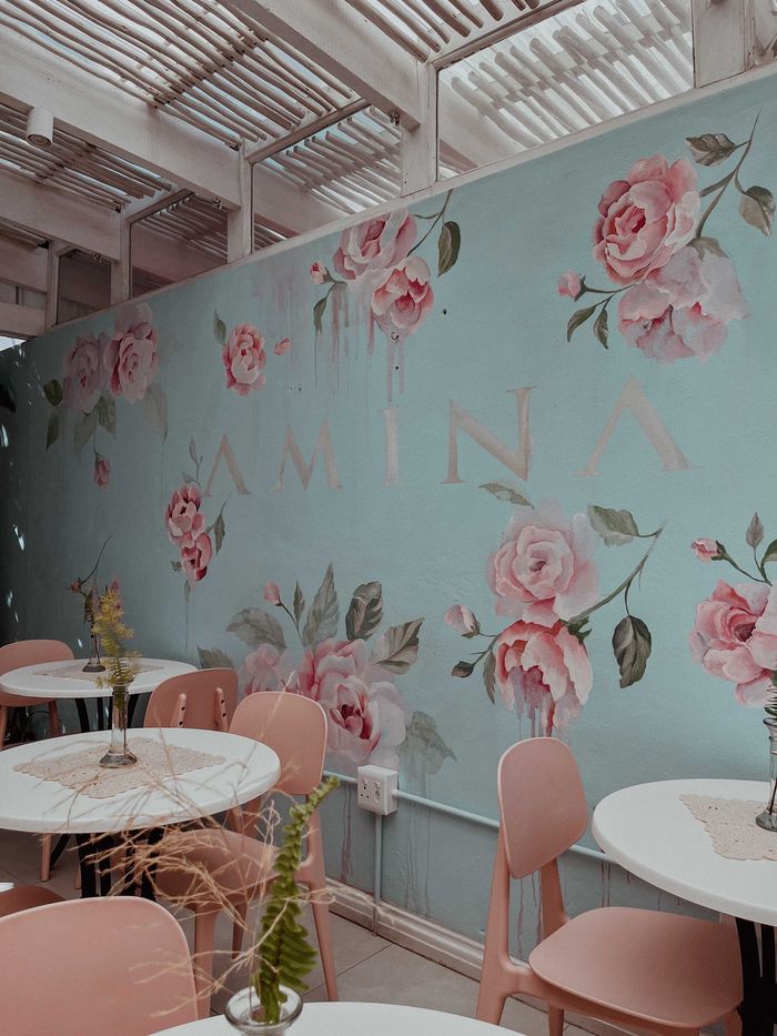 The Morning Palette: pink chairs and round white tables under a mural of pink roses