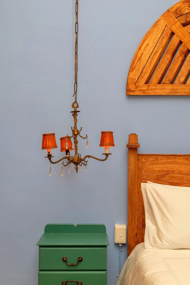 An antique chandelier and the carved headboard in the blue room